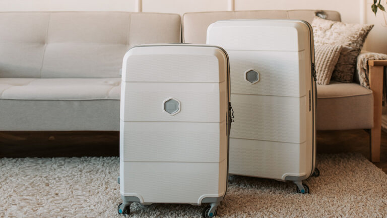 Two hard-cased, wheeled suitcases on a shaggy carpet.
