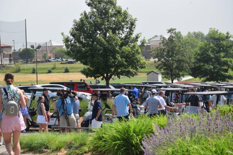 Group of individuals in and by golf carts